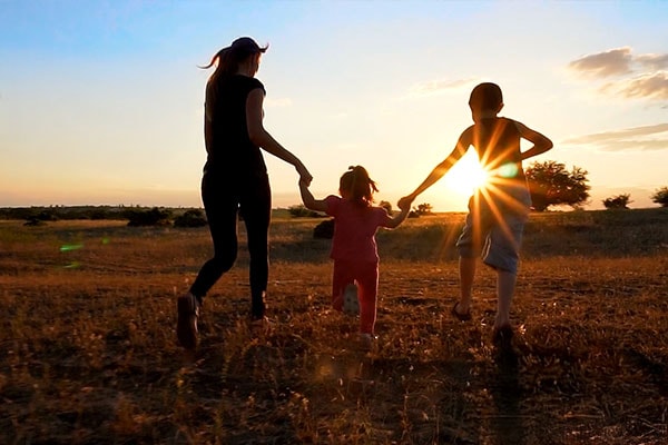 Woman and children running through a field