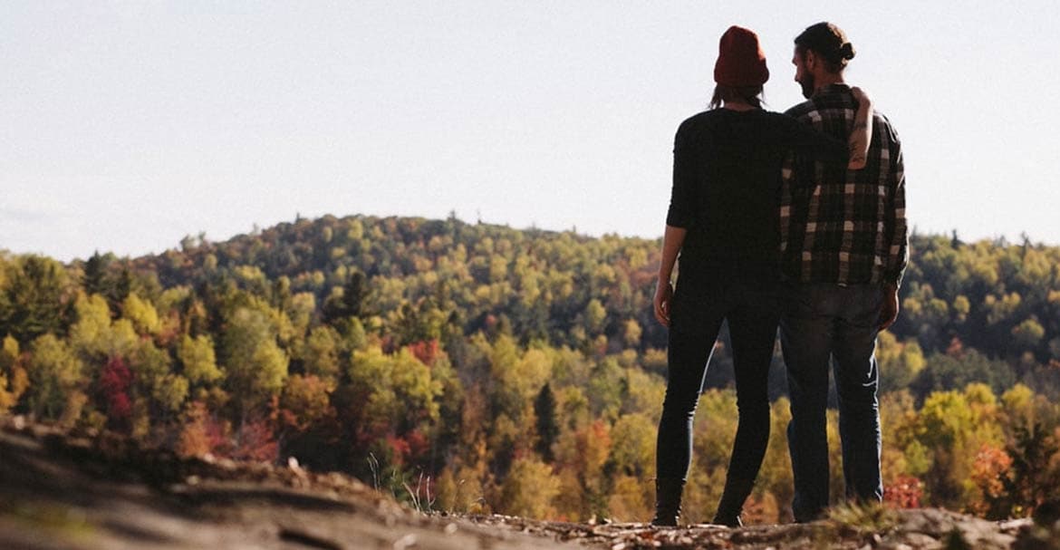 Two people standing in fall leaves