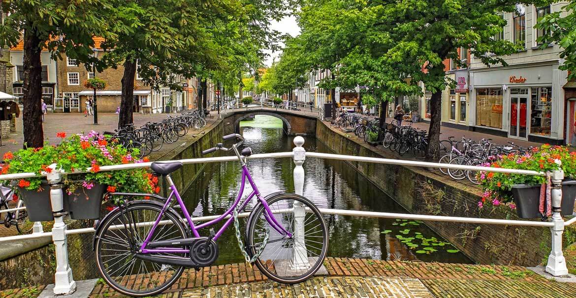 Street view with a bike on a bridge over the canal.