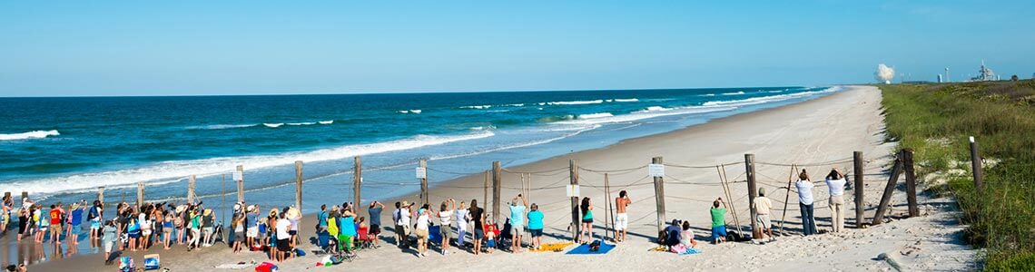 Spectators watching a rocket launch on Canaveral National Seashore in FL