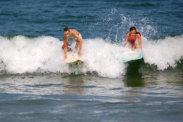 Girls surfing at Virginia Beach, VA