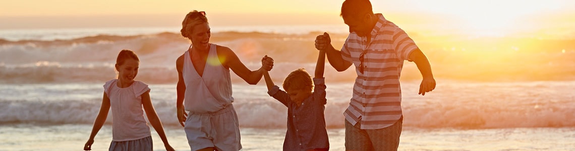 family enjoying their low rate at the beach