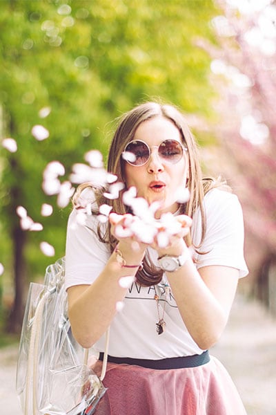 Woman blowing spring flowers