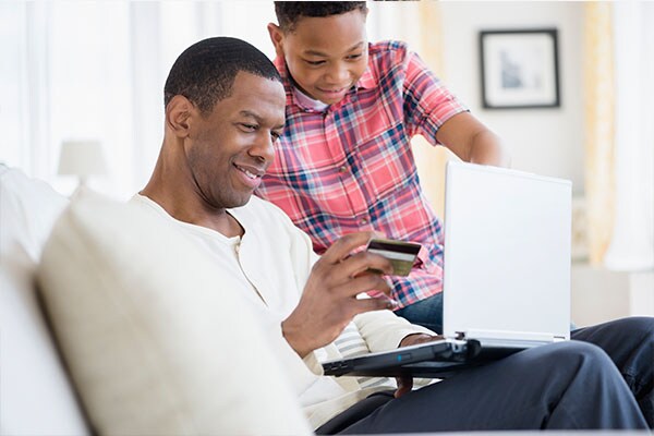 Best Western Rewards Loyalty Program Man And Son Sitting On Couch Looking At Bwr Ping Mall